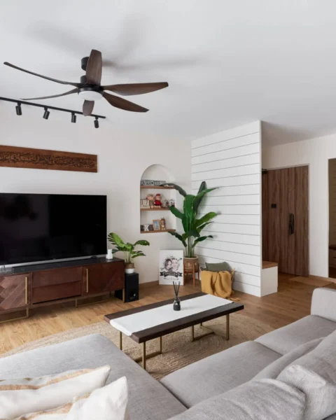 Cosy 4-room HDB living room with wood TV console, track lights and L-shaped sofa