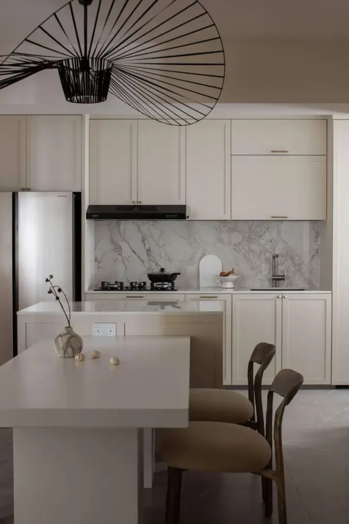 Elegant marble backsplash and island in soft neutral kitchen cabinetry
