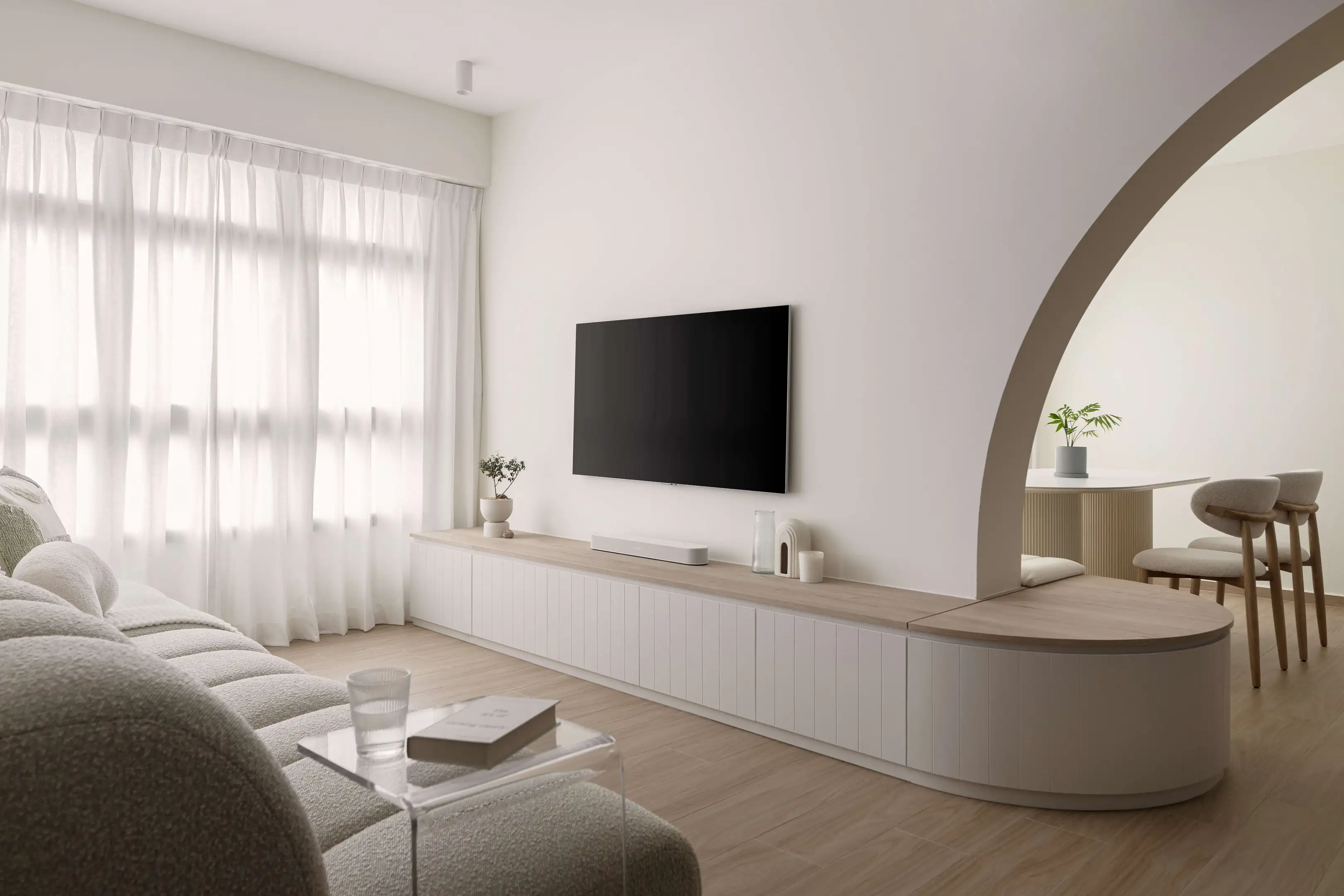 Bright minimalist HDB BTO living room with long TV console and arch to dining area
