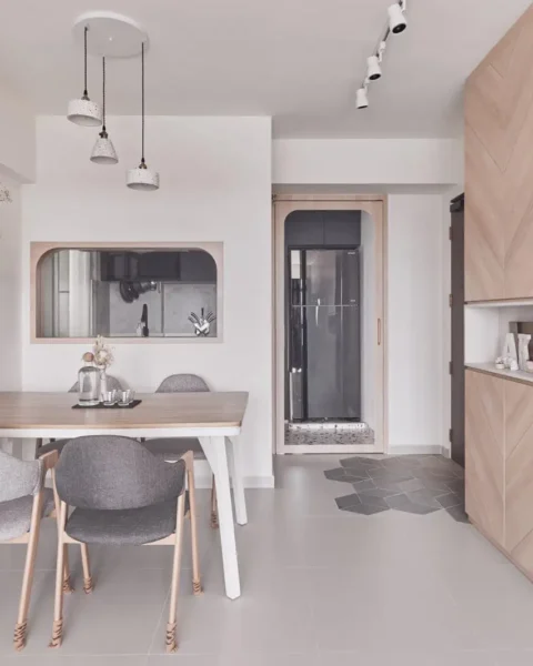 Scandinavian homes interior design – dining nook with light-wood herringbone cabinet, grey upholstered chairs, and pendant trio.