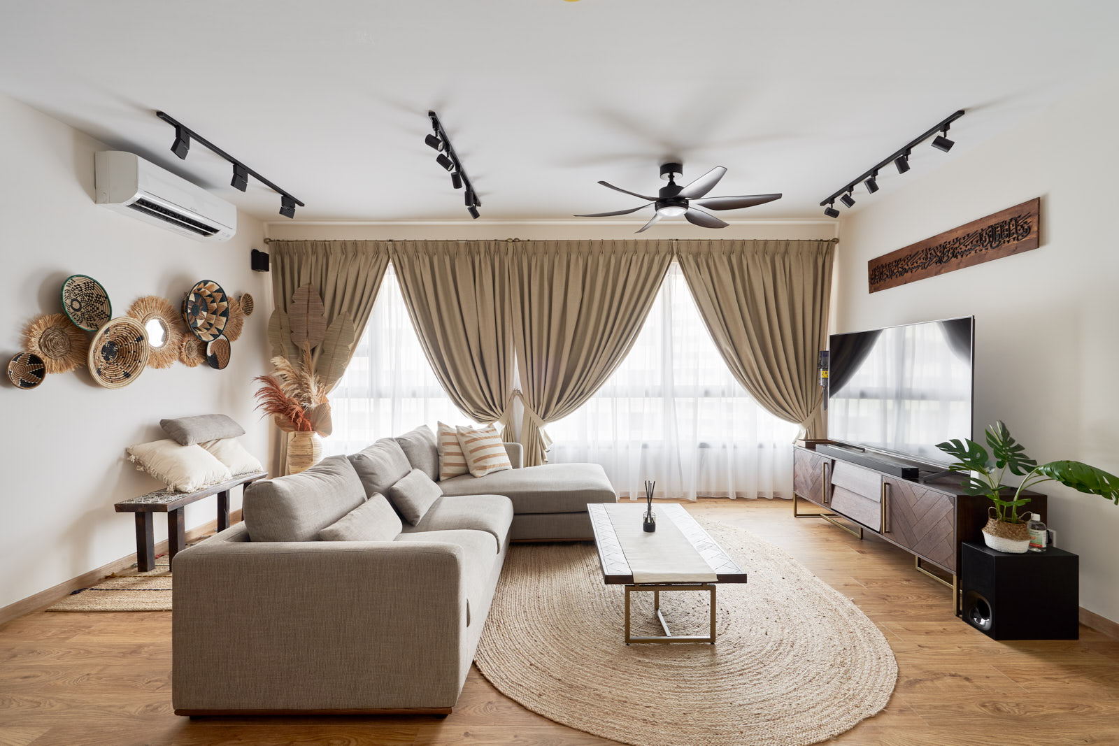 Cozy 5 room BTO design living room with warm wood flooring, woven rug, and layered neutral seating for relaxed gatherings.