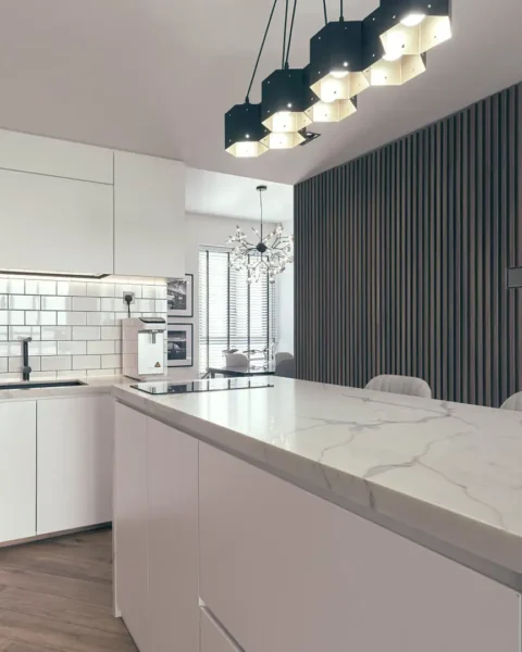 luxury open plan kitchen with marble island and timber feature wall