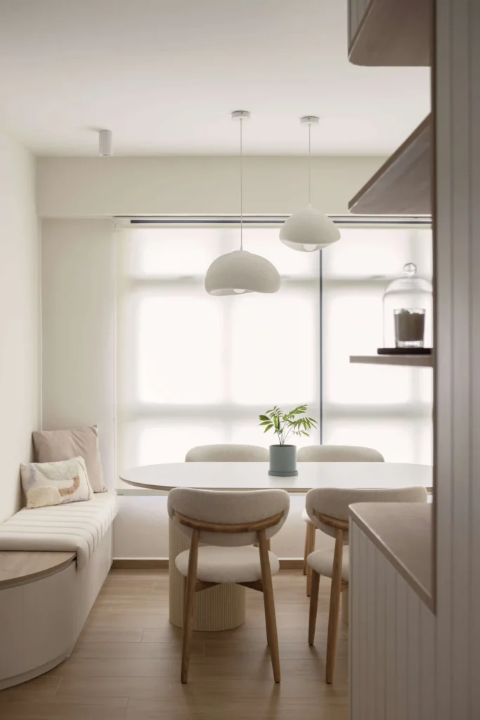 Scandinavian dining nook with built-in banquette, rounded table and soft dome pendants in an HDB BTO