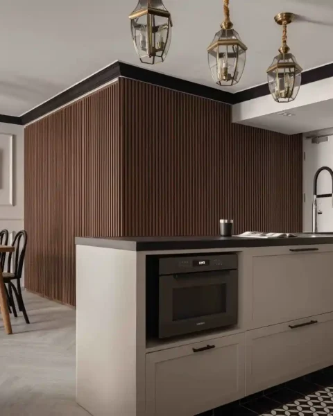 Modern-colonial kitchen with fluted wood feature, shaker cabinets and brass lantern pendants
