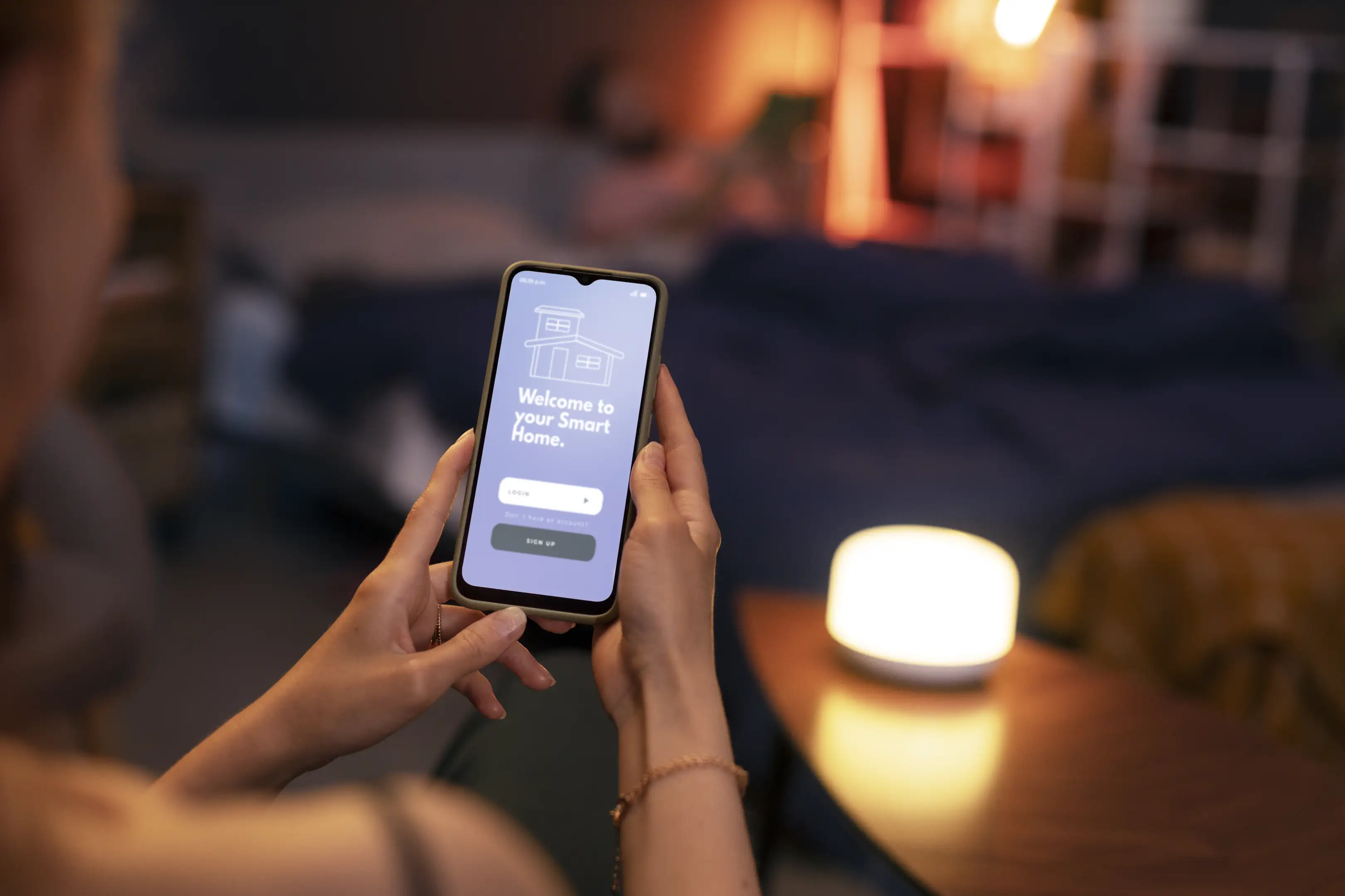 Renter uses a phone app to dim a bedside smart lamp in a cozy bedroom—no wiring or drilling needed.