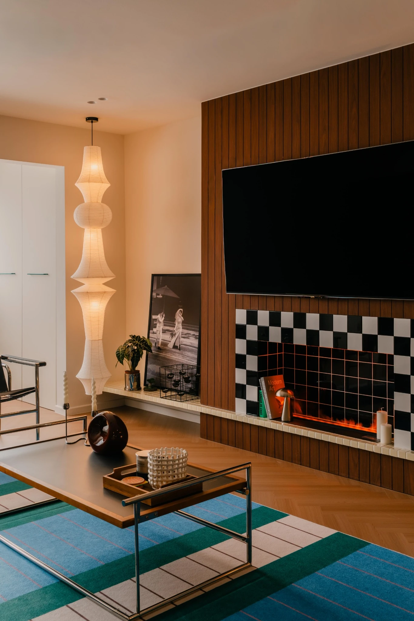 Retro-inspired TV wall with vertical wood paneling, checkerboard tiles, and a fireplace-style feature niche.