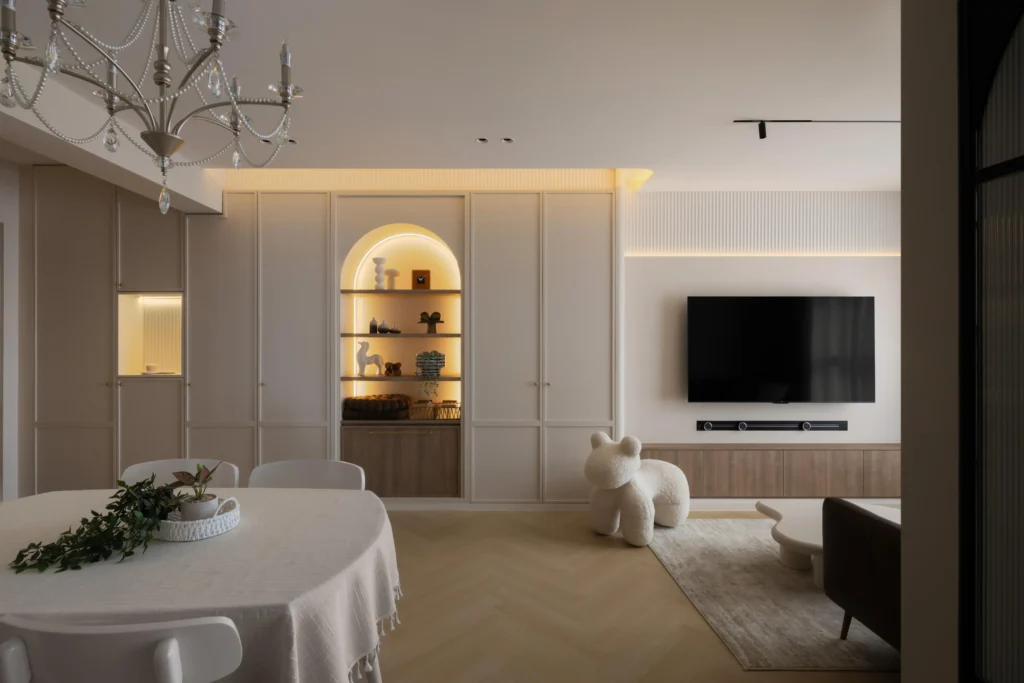 Living room wall with warm panels and an arched display niche with hidden lighting beside a dining table.