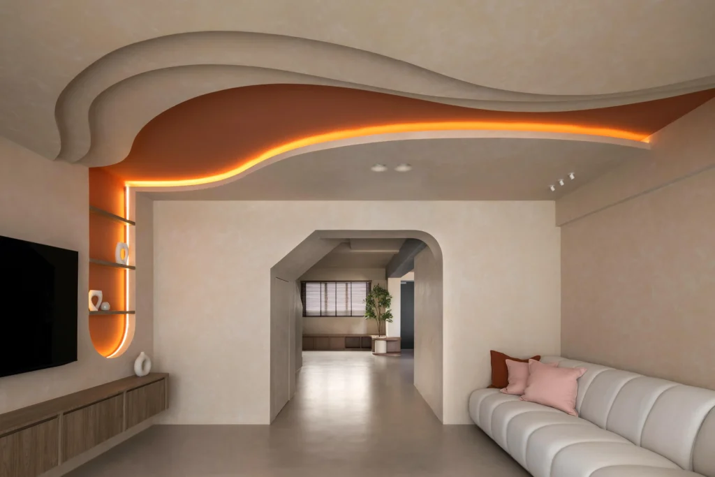 Living room with a curved ceiling feature and warm cove lighting above a sofa and TV wall.