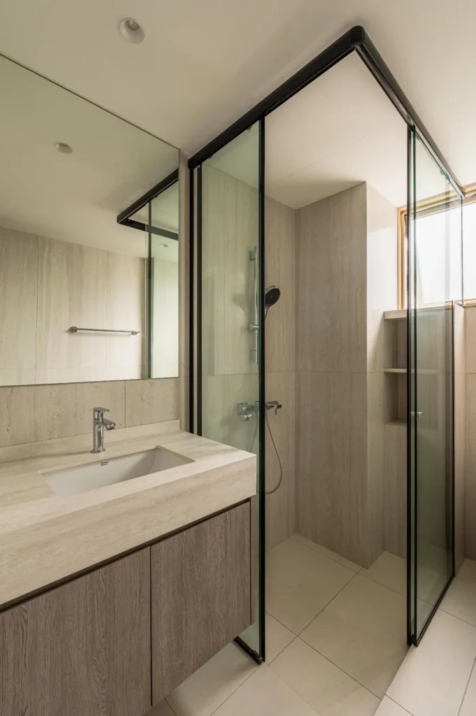 Glass shower screen separating wet and dry areas in modern condo bathroom renovation Singapore by Lemonfridge Studio